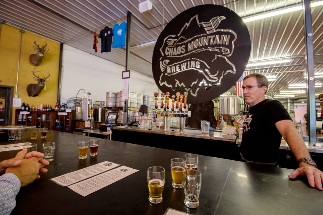 A man standing behind a bar with beers on it
